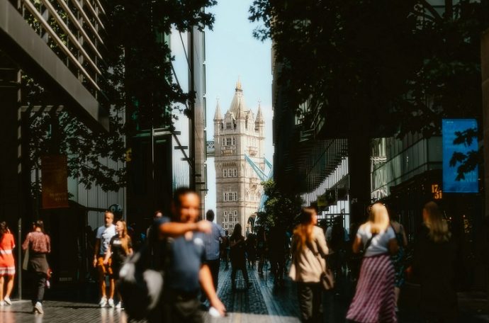 A picture of Tower bridge with crowds of people in the sunshine. Photo by Alin Gavriliuc on Unsplash