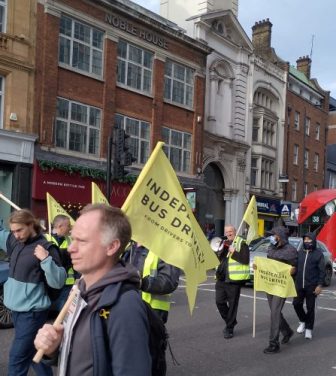 London bus drivers march to TfL headquarters carrying flags and banners.