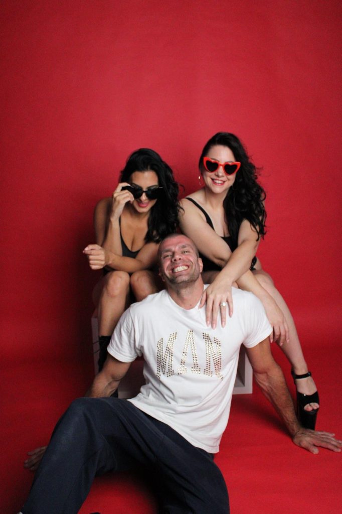 Two women and a man smiling for a photoshoot 