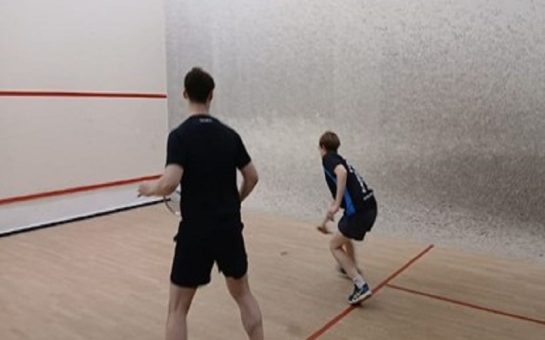 Two people playing squash on a squash court. Credit: Jonny Singh