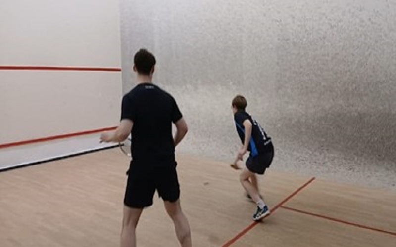 Two people playing squash on a squash court. Credit: Jonny Singh