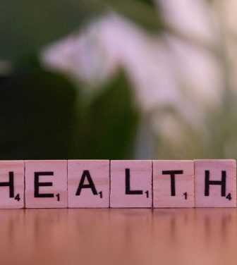 pink scrabble letters standing on a table reading HEALTH