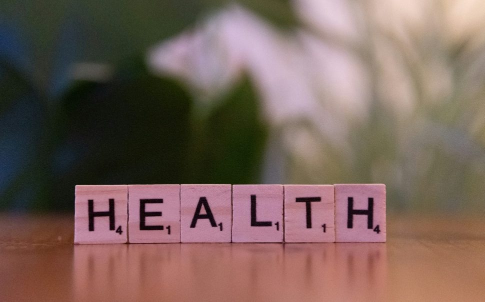 pink scrabble letters standing on a table reading HEALTH
