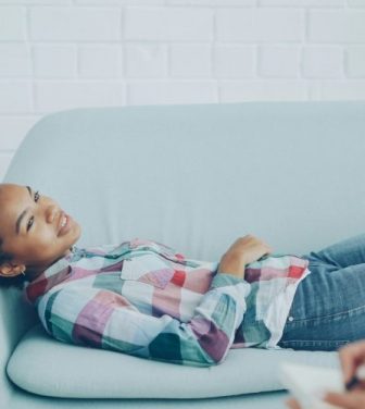 Teenager lies on sofa in discussion with her councillor