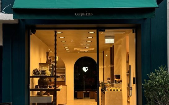 Copains London bakery storefront green canopy with business name and warm bakery interior