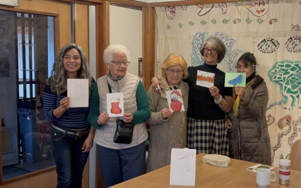 Old women holding up their art work