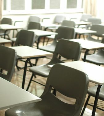 Desks and chairs in an empty school classroom.