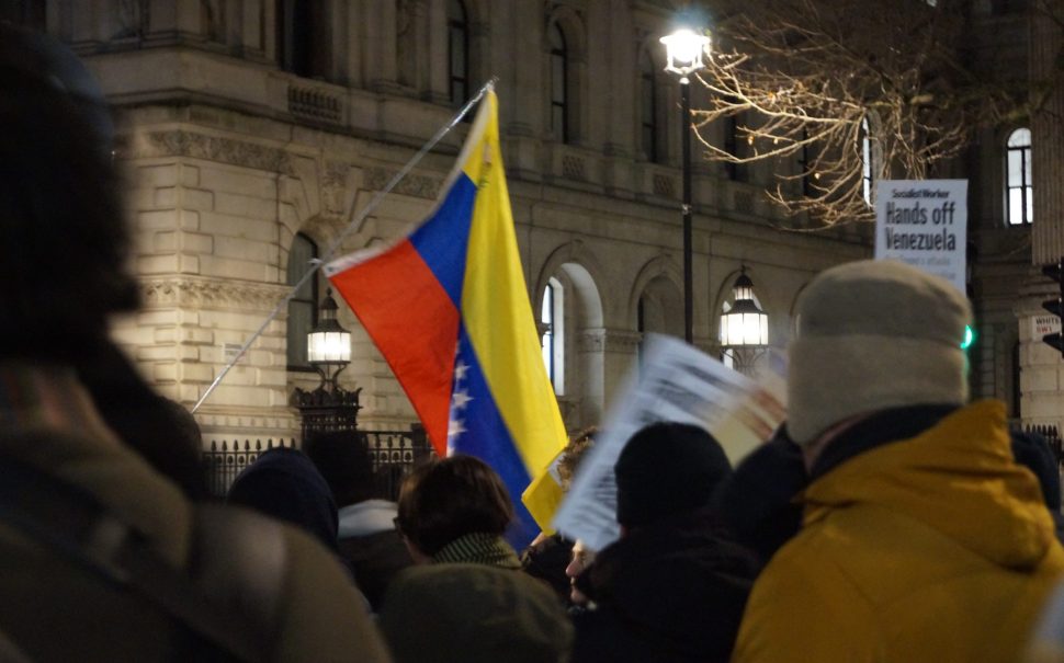 A Venezuelan flag waves in the wind at a protest against Trump's invasion of the country. Credit: Megan Norcott.