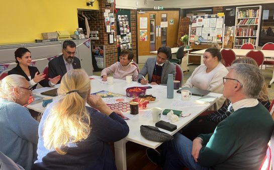 Multicultural Richmond staff sit at a table with attendees.