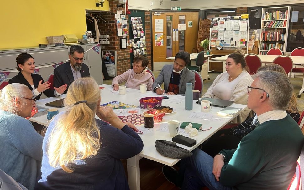 Multicultural Richmond staff sit at a table with attendees.