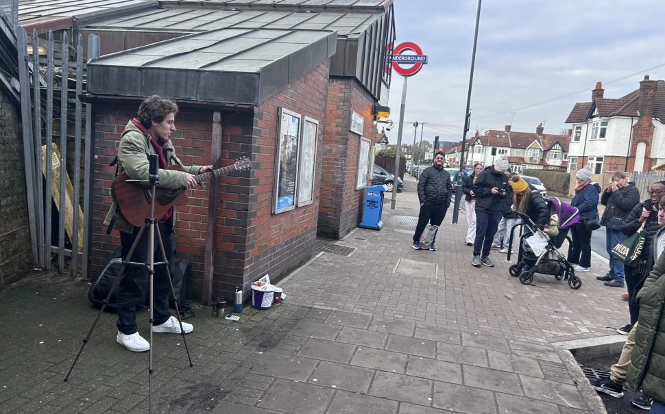Man performs to crowd outside tube station