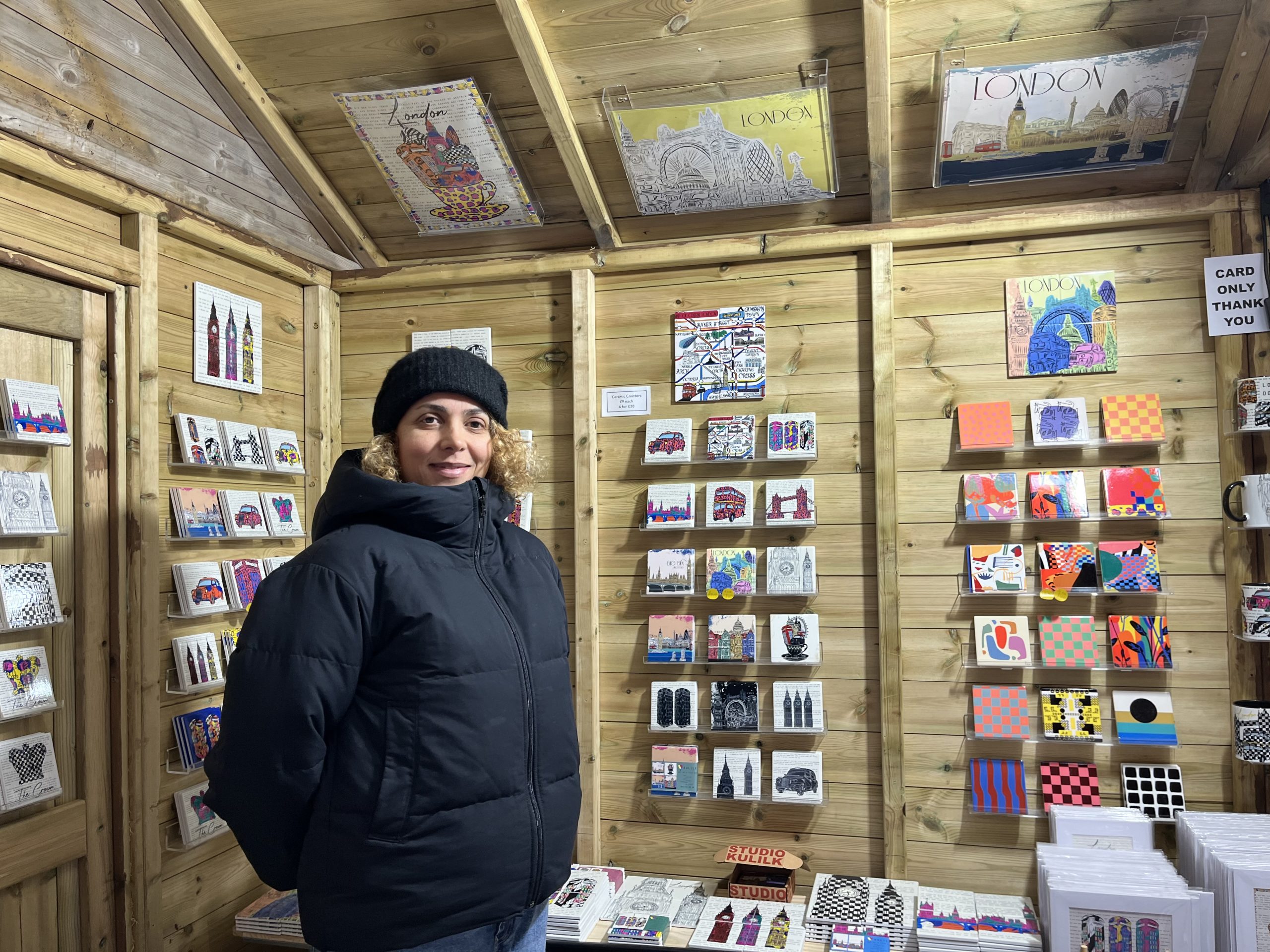 Lady stands in front of her artworks for sale.