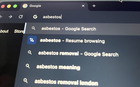 The word 'asbestos' is being typed into a browser.