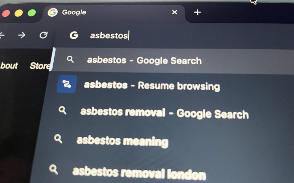 The word 'asbestos' is being typed into a browser.