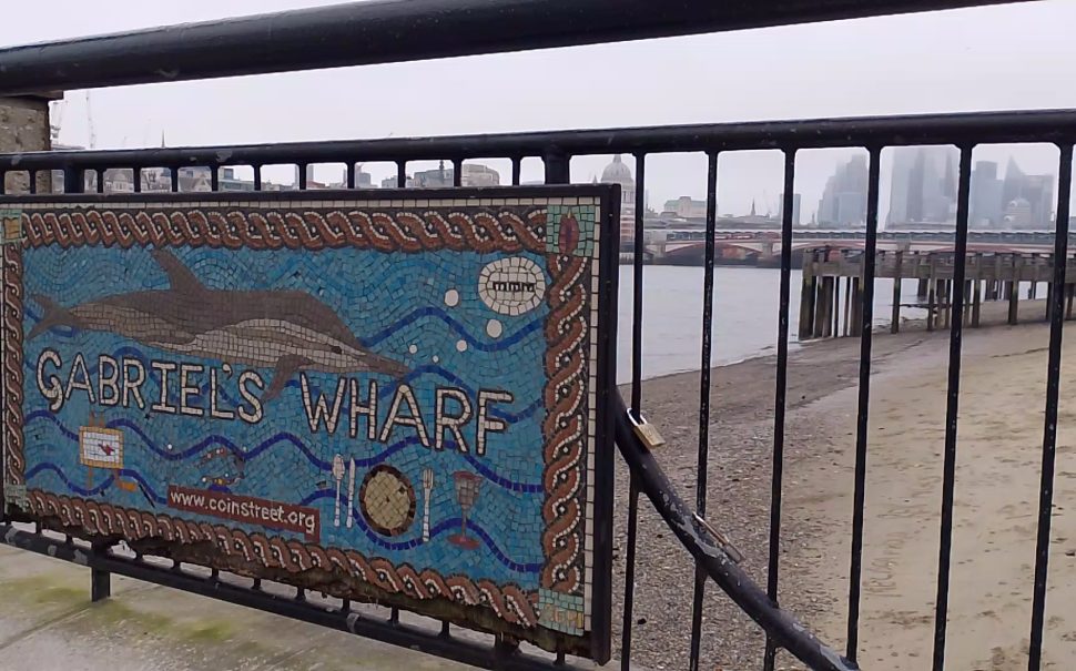 A mosaic sign for Gabriel's Wharf, on London's South Bank. Towers in the City of London can be seen in the distance.