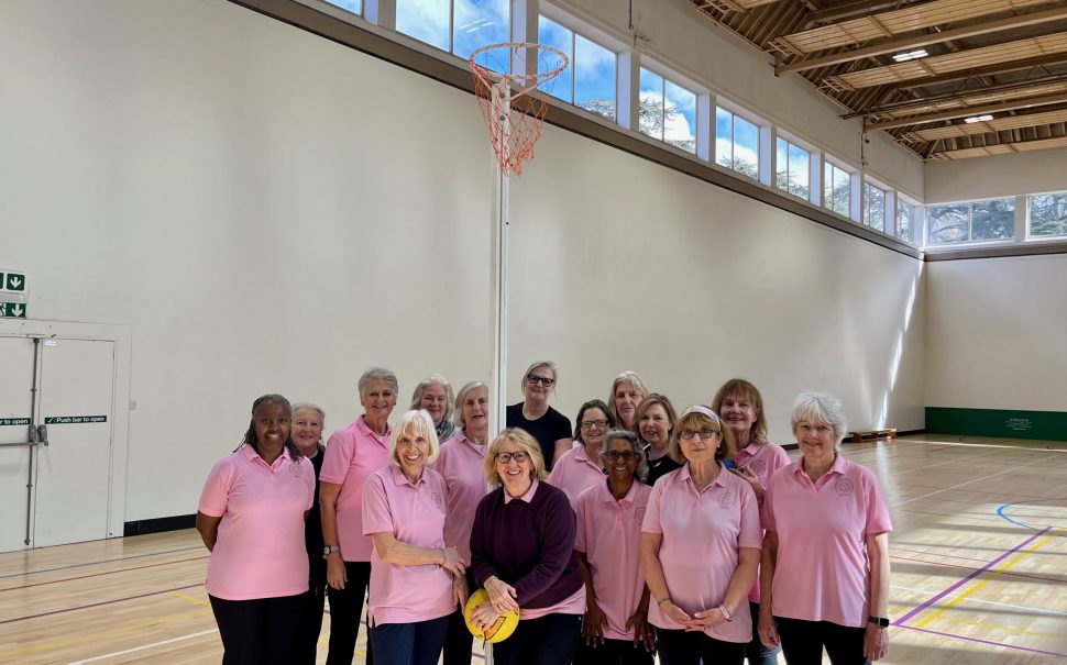 Ladies dressed in pink on a netball court