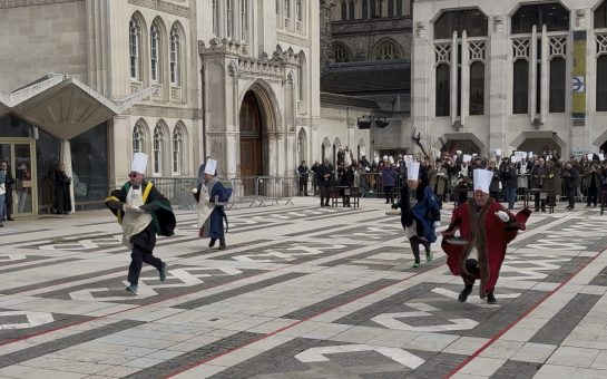 People wearing Chefs hats and cloaks running and flipping pancakes