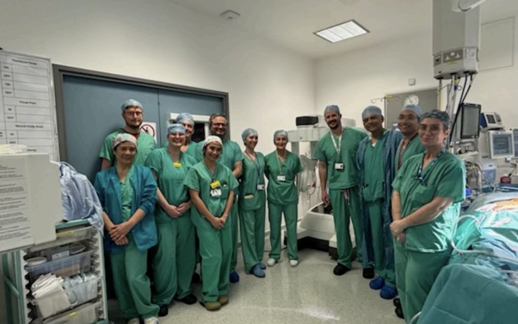 the robotic cardiac team standing in together an operating theatre