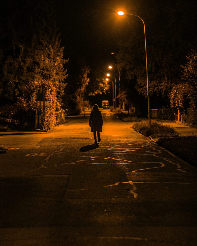 woman walking on darkly lit street