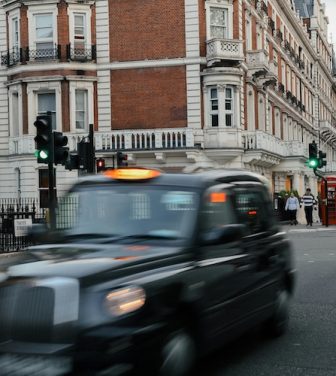 A Black-Cab zooms along a typical central London street.