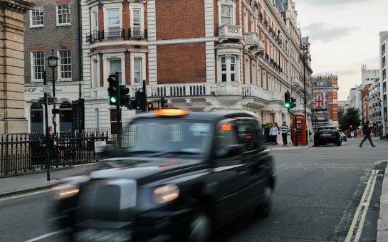 A Black-Cab zooms along a typical central London street.