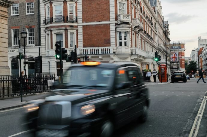 A Black-Cab zooms along a typical central London street.
