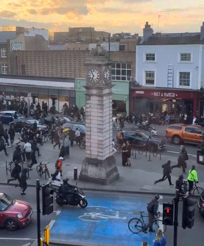 Large group of people runing down high street
