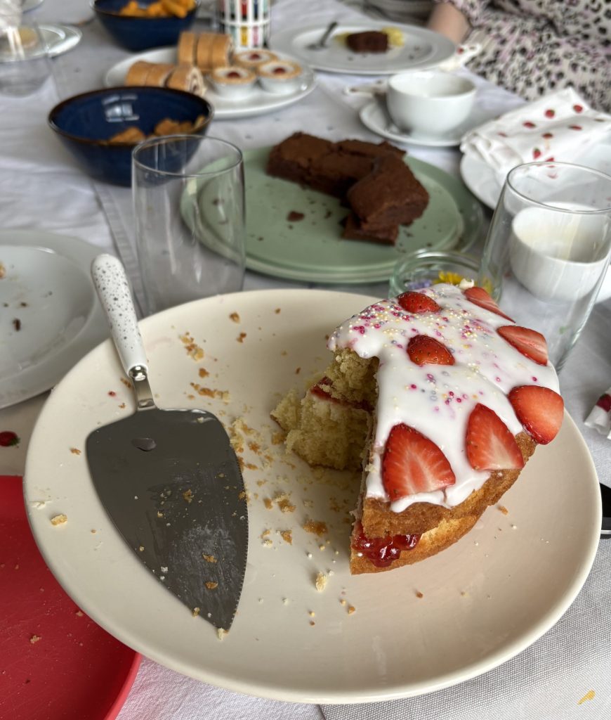 A sponge cake with strawberries on a cake stand.