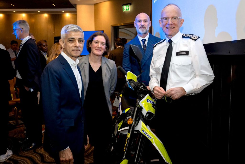 London Mayor Sadiq Khan and Met Commissioner Sir Mark Rowley pose with guests and a police e-bike at the International Mobile Phone Crime Conference.