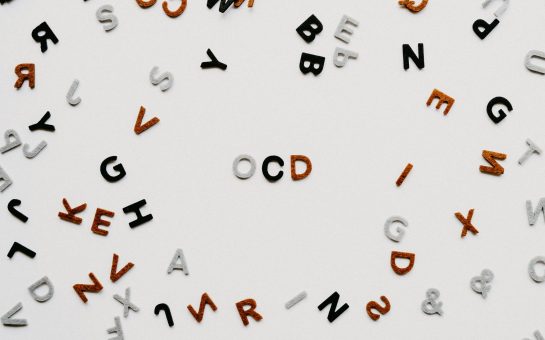 Fridge magnet letters on a fridge with the letters O, C and D in the middle.