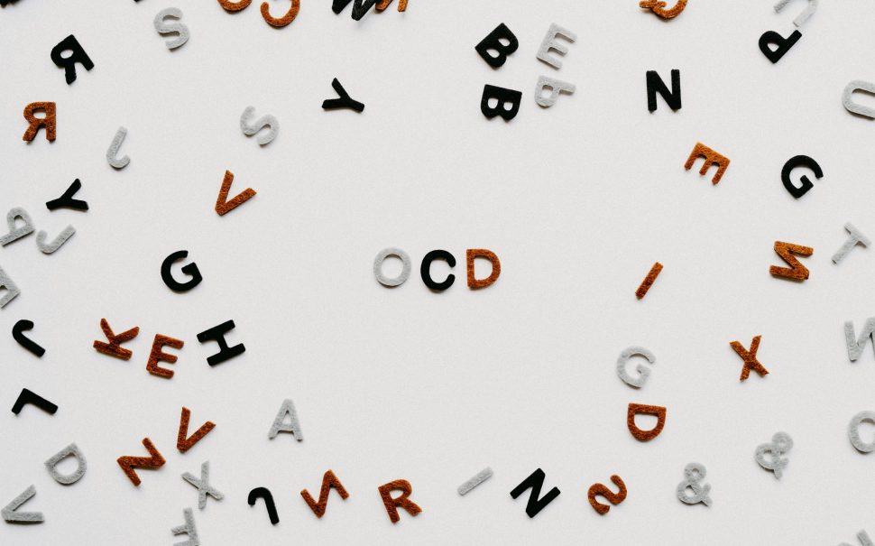 Fridge magnet letters on a fridge with the letters O, C and D in the middle.