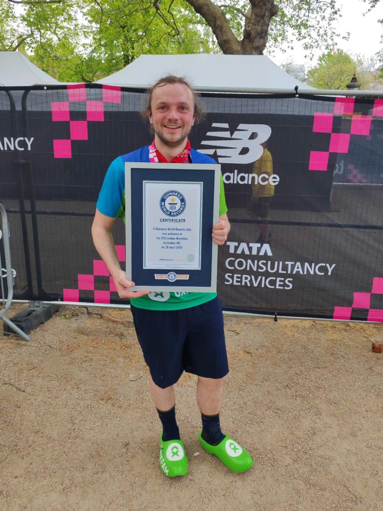 Jorden Teunissen in his clogs after the marathon with his Guiness World Record certificate 