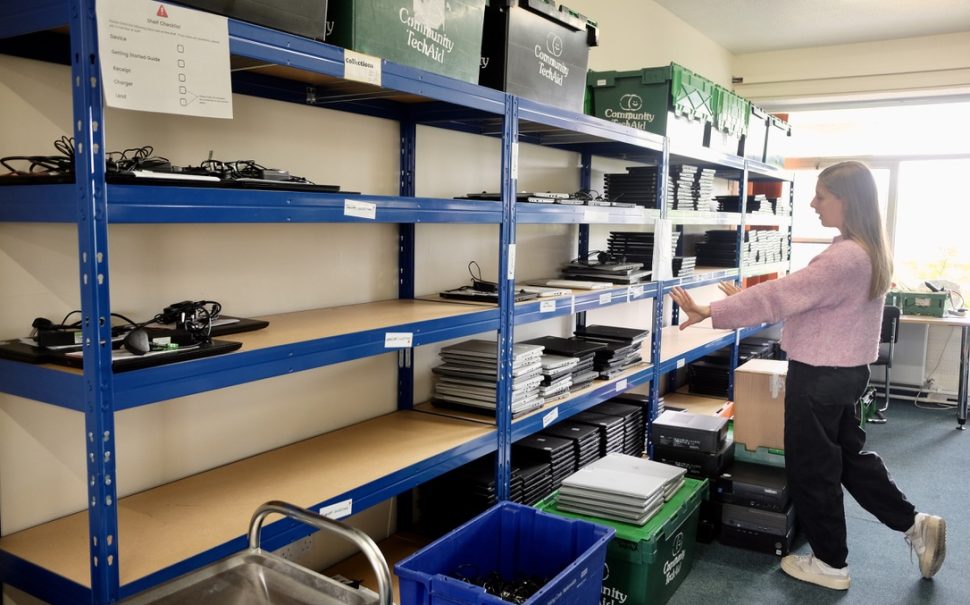 A person explores some shelves with community donations on