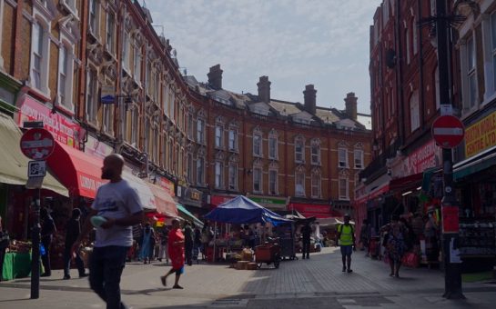 Locals stroll around Brixton Market, a street lined with colourful shops and stalls
