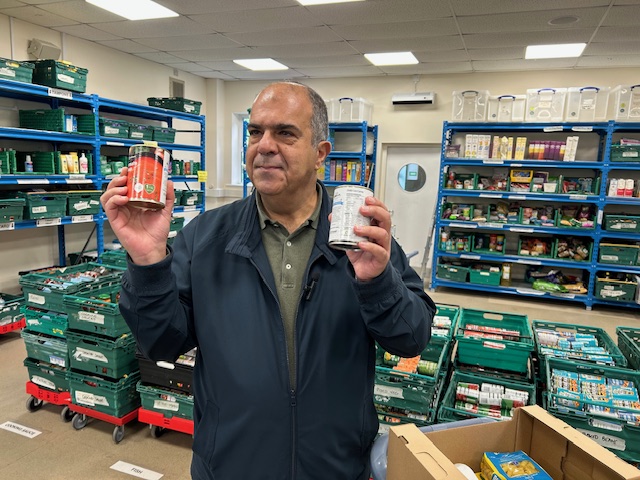 Sir Stelios Haji-Ioannou holding the tins of soup EasyJet donated