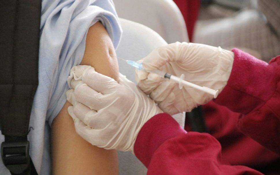 Person injected in the arm with a vaccine