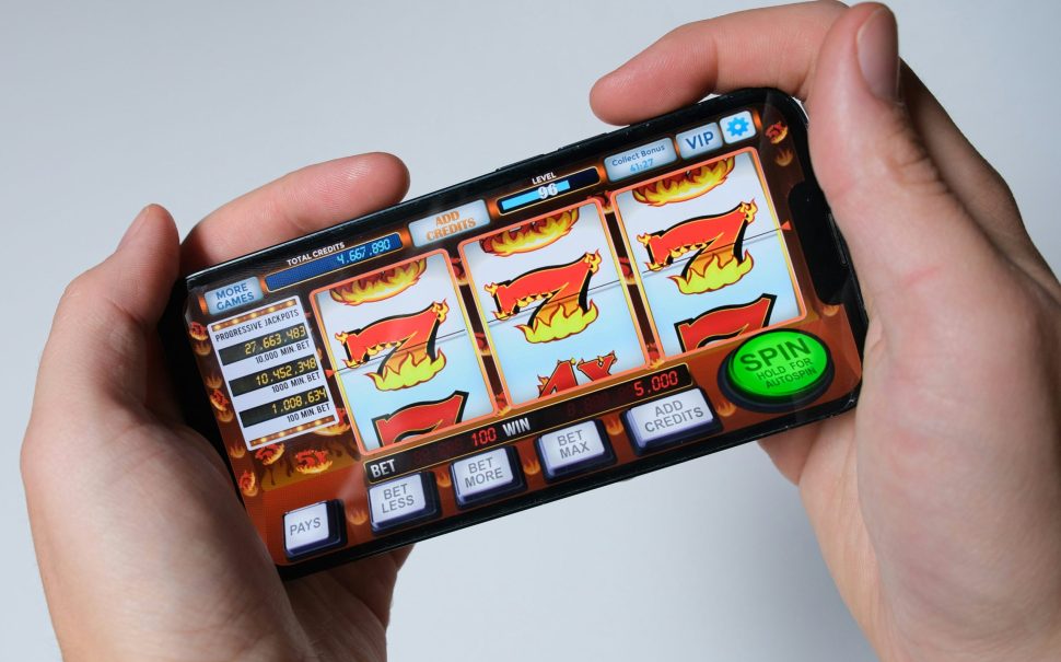 A person playing slots on a mobile phone (Credit: Free to use from Unsplash)