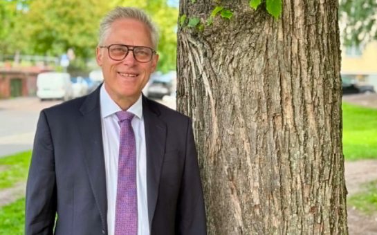 A Norwegian Catholic priest appointed as the new Vice Chancellor at St Mary’s University London standing by a tree.