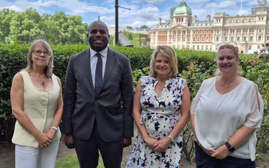 Deputy Prime Minister David Lammy stands with three women outside.