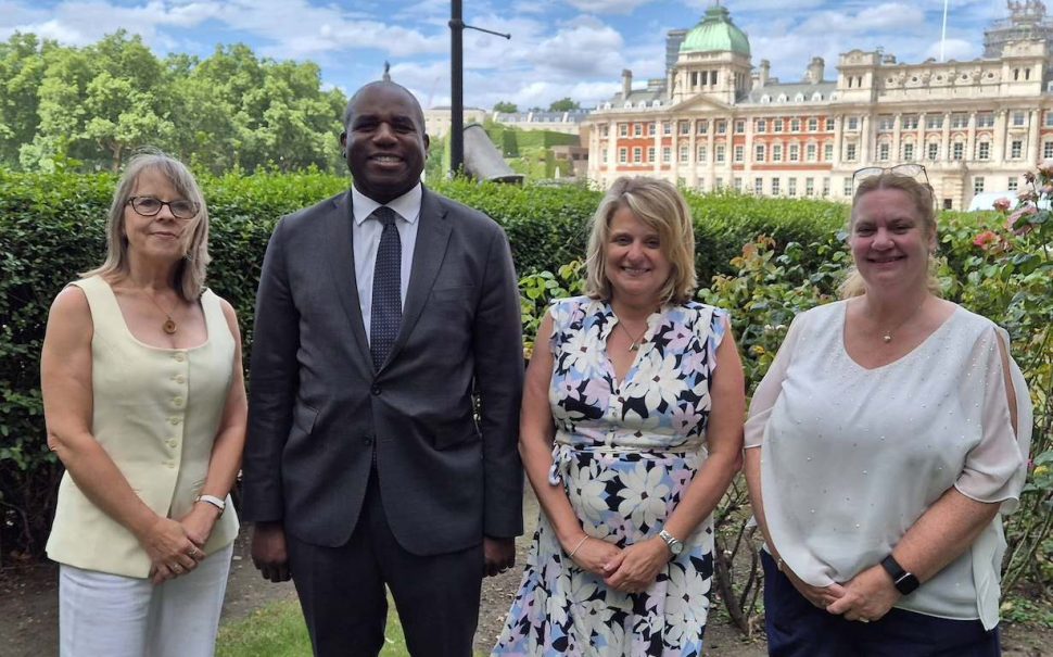 Deputy Prime Minister David Lammy stands with three women outside.