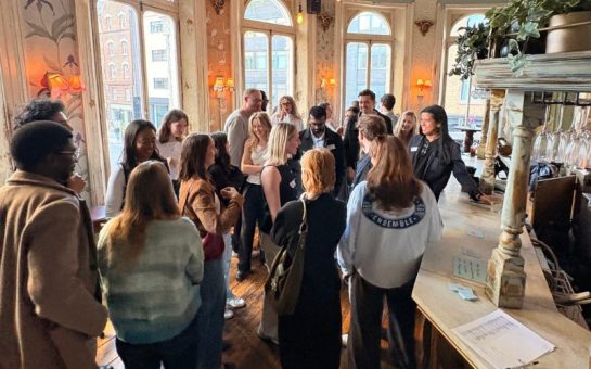 A group of strangers are standing in a pub at a small talk event socialising