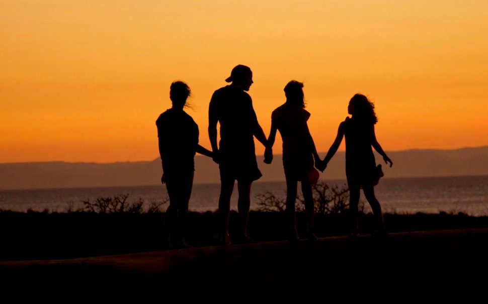 Unsplash image of silhouette family in title about cost of children