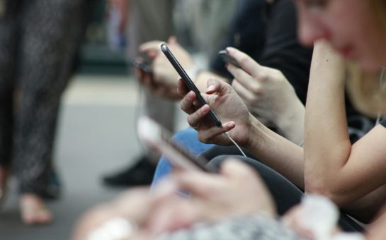 Person holding phone in crowded space