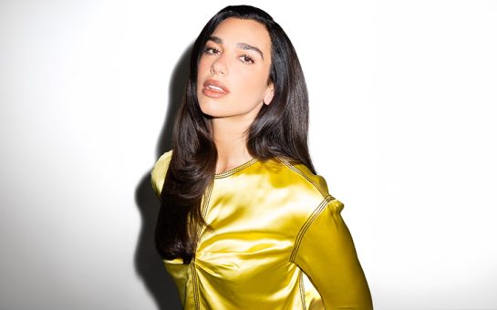 Dua Lipa in a yellow satin dress.