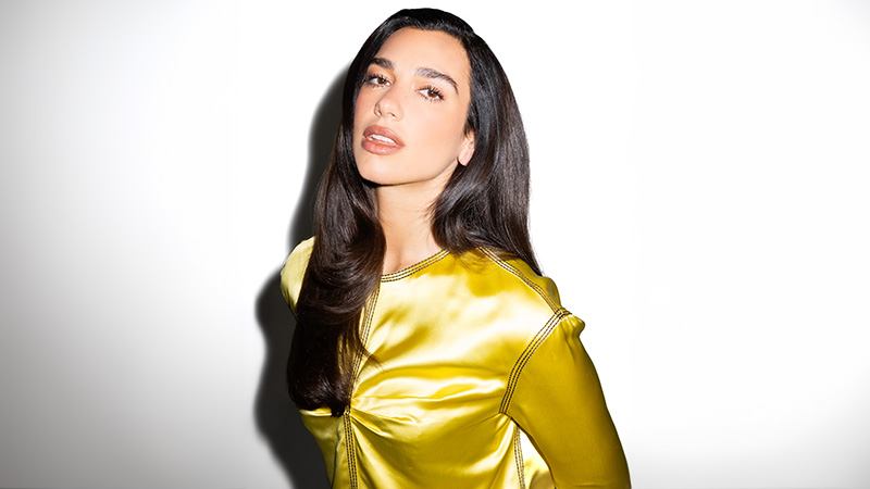 Dua Lipa in a yellow satin dress.