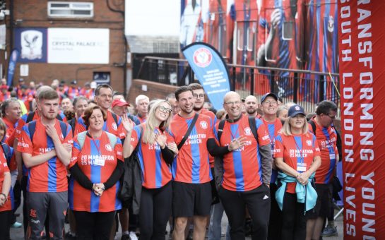 Marchers in Palace for Life's Marathon March on the start line on red and blue striped tops, at Selhurst Park