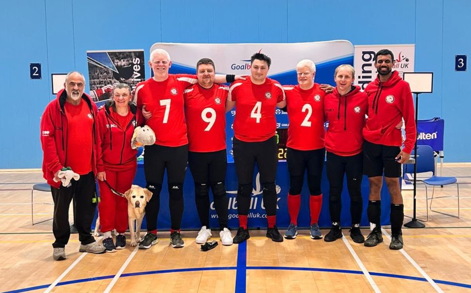A photo of the London Elephants Goalball team in a sports hall.