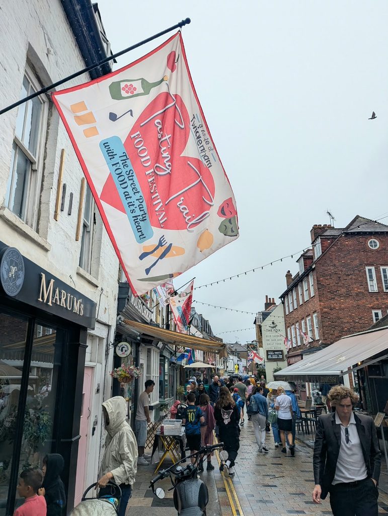Festival flag flies high above street of people Twickenham's Food Trail Festival flag flies high above crowds on Church Street, who flocked to the festival despite the rain
