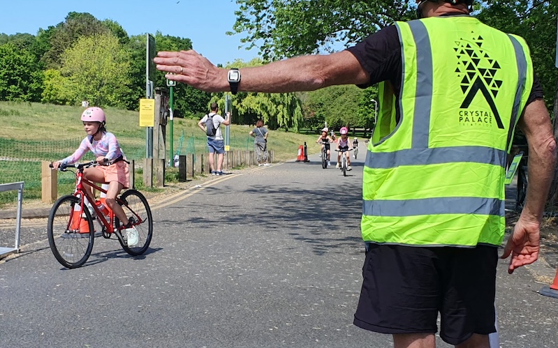 A race marshal directs competitors at the Crystal Palace Triathlon.