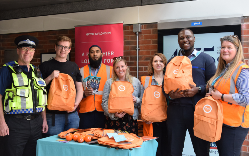 Uniformed police member and organisers with Thrive London's orange grab bags